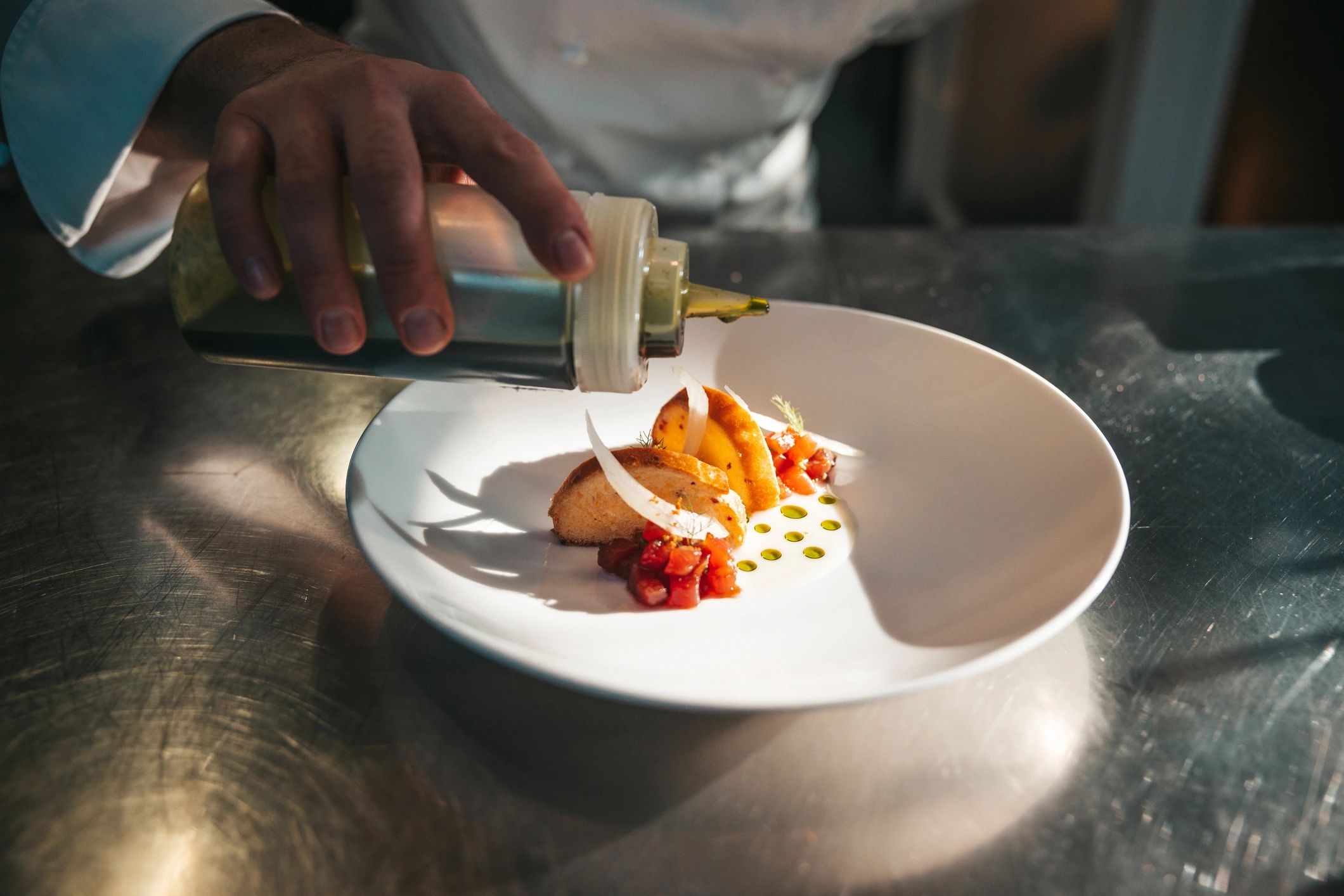 Chef plating a dish in a restaurant kitchen