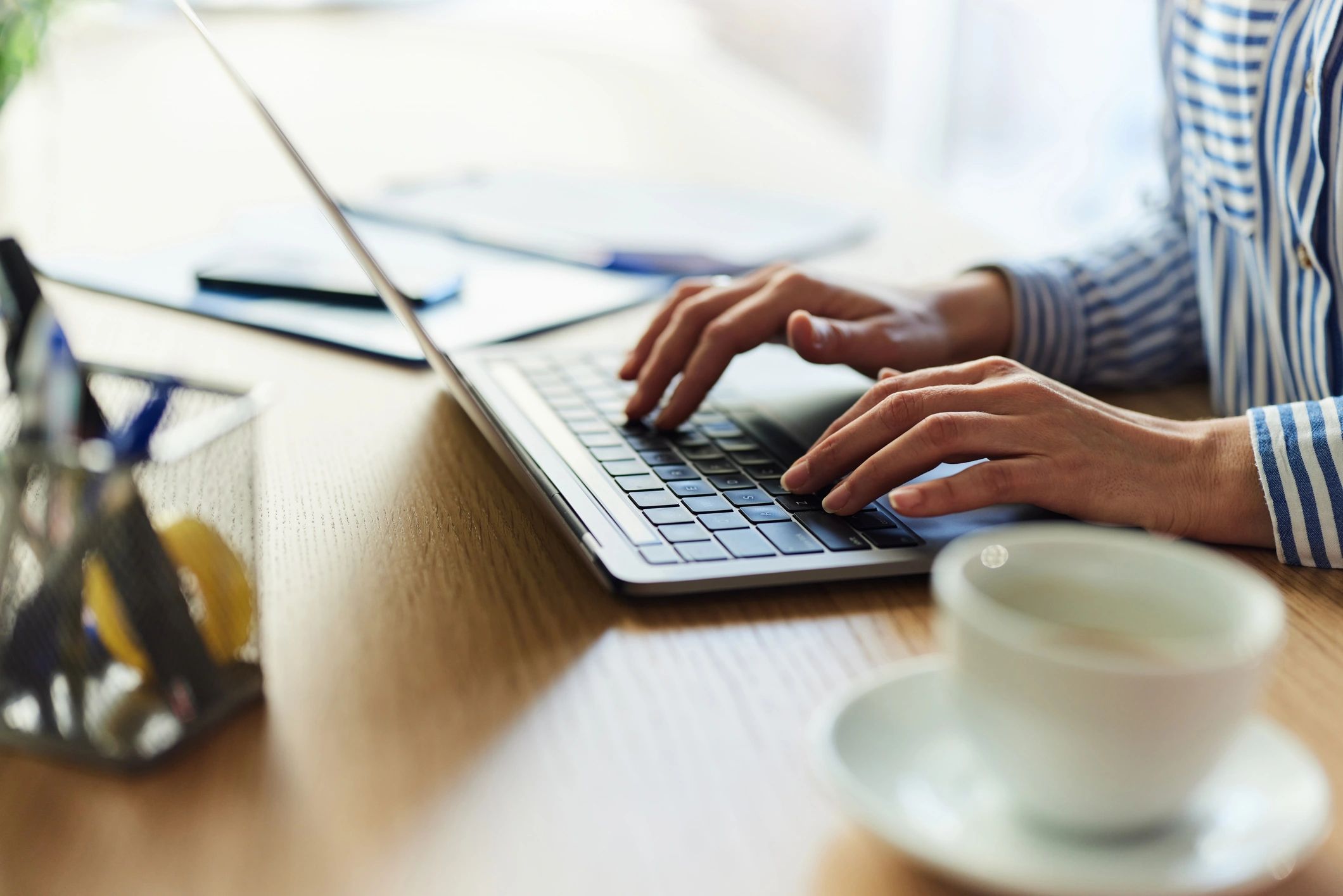 Close up of a businesswoman working on laptop in the office.