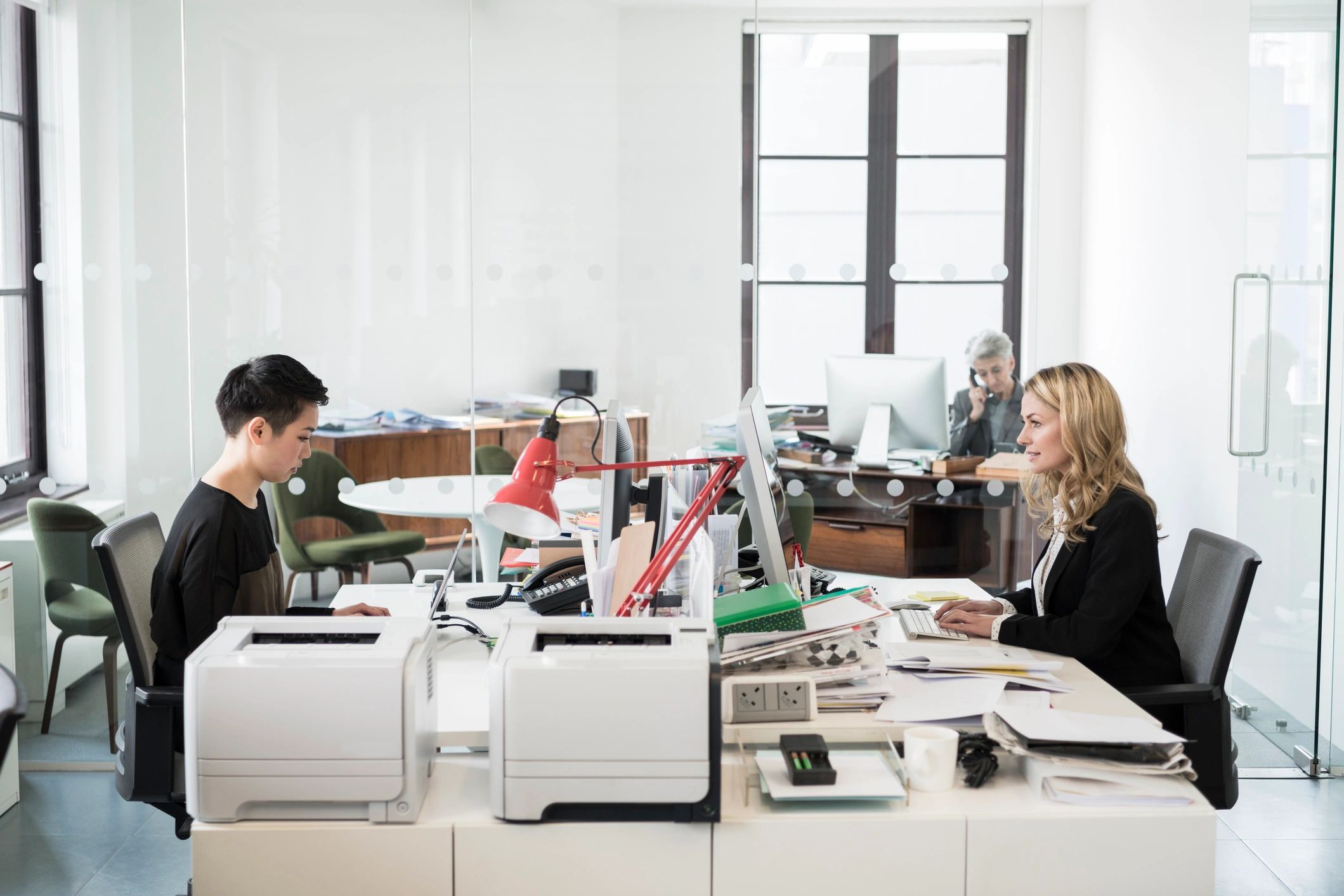 Editors working at computers in a bright office