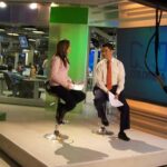 Periodista de televisión en estudio de noticias