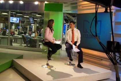 Periodista de televisión en estudio de noticias
