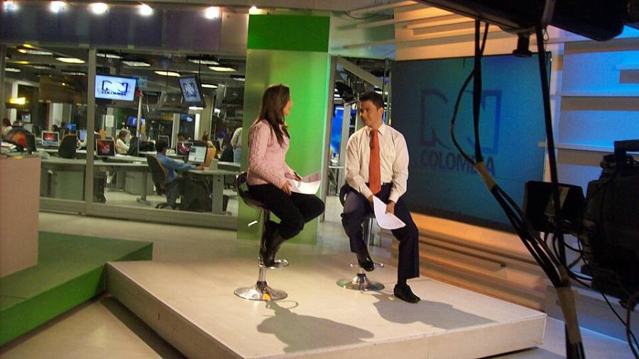 Periodista de televisión en estudio de noticias