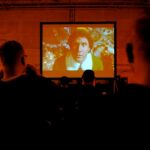 Personas viendo una película en pantalla grande