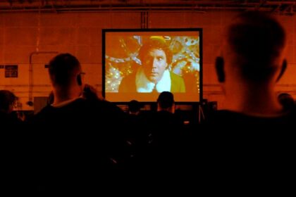 Personas viendo una película en pantalla grande